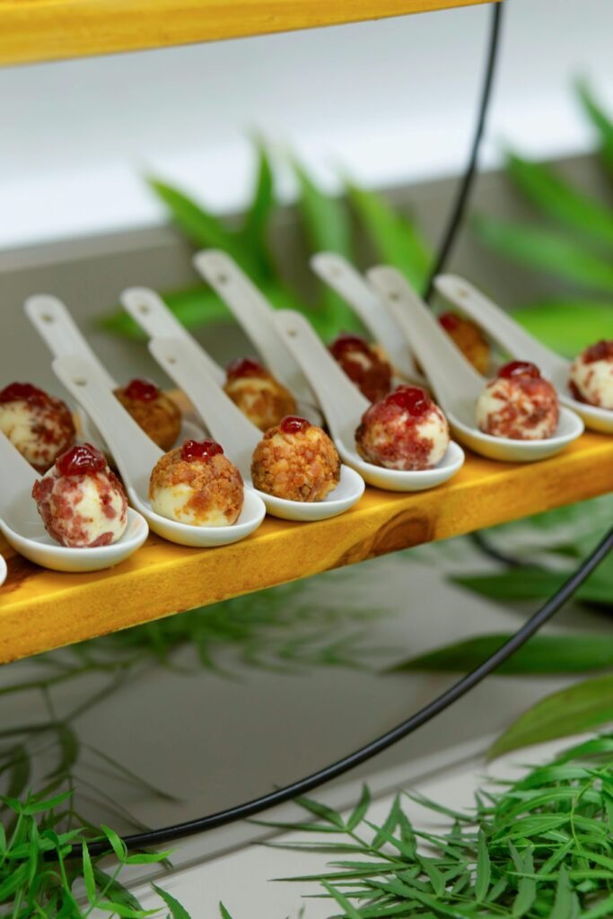 Elegant display of appetizers on ceramic spoons at a culinary event in Belo Horizonte, Brazil.